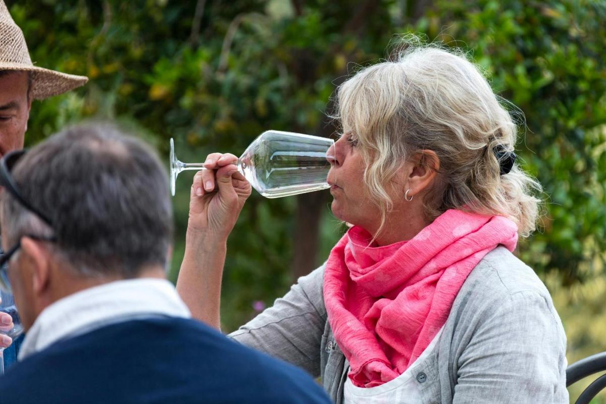 a woman drinking a glass of wine with a man