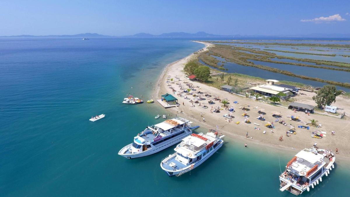 three boats in the water next to a beach