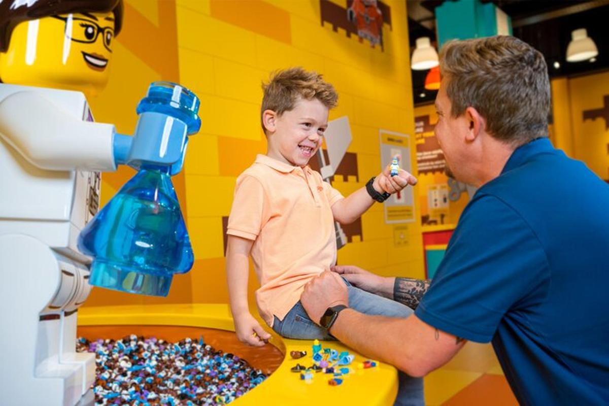 a man helping a young boy play with lego