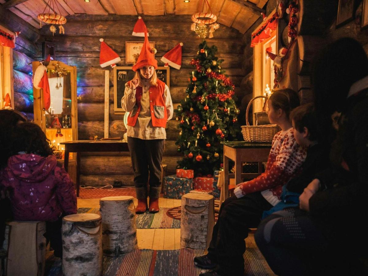 a woman standing in a room with a christmas tree