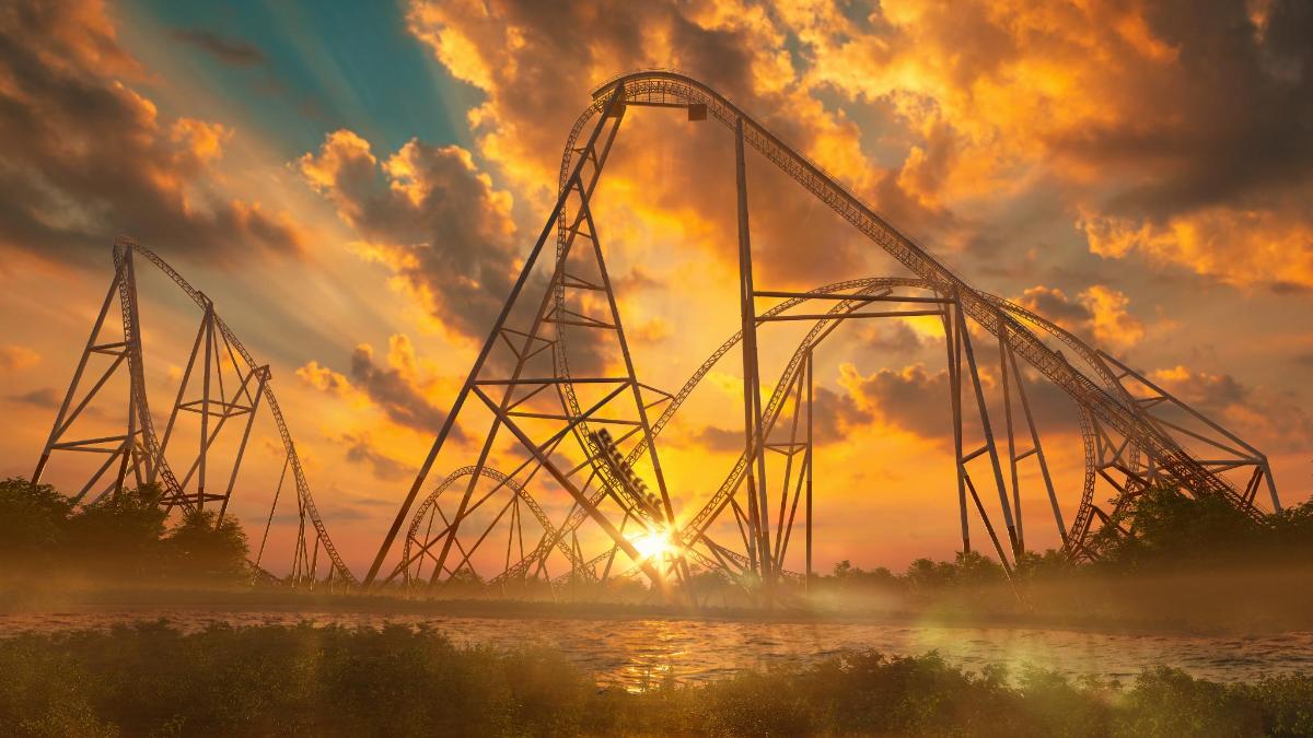 a roller coaster on the water at sunset