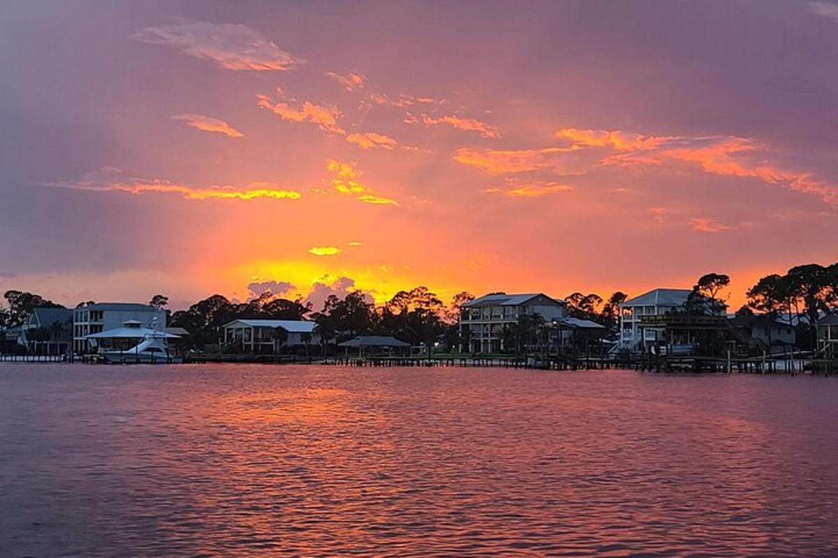 a sunset over a body of water with houses