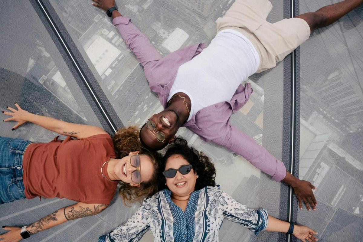 a group of three women standing on a glass walkway