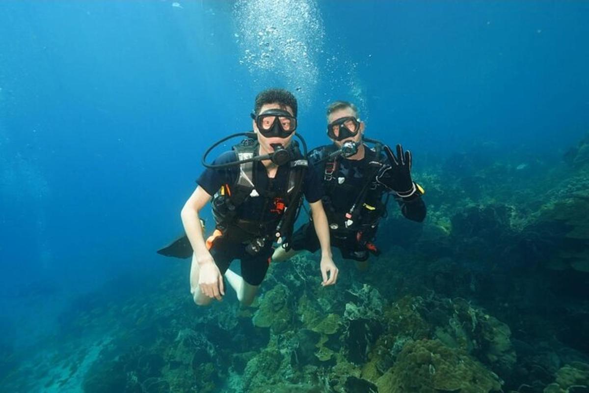 two men in scuba gear swimming in the ocean