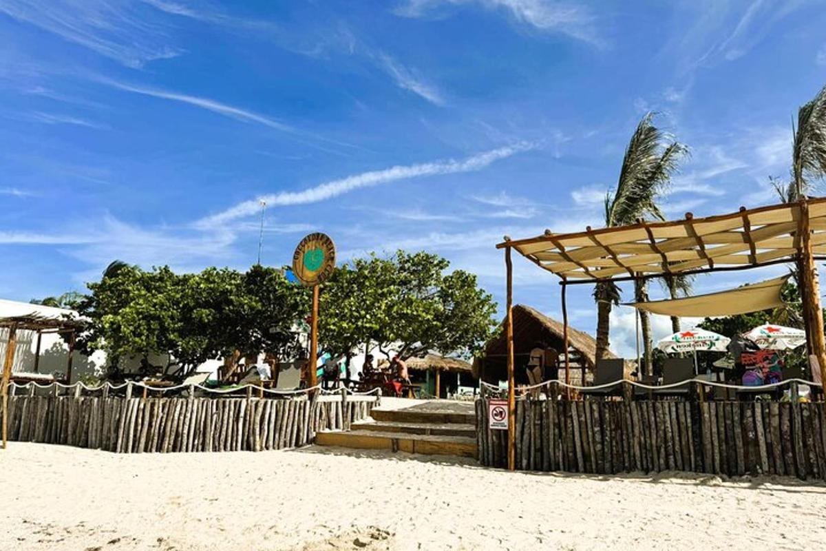 a beach with a wooden fence and a pavilion