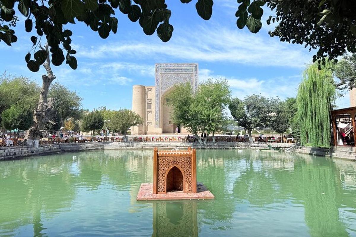 a pond in a park with a building in the background