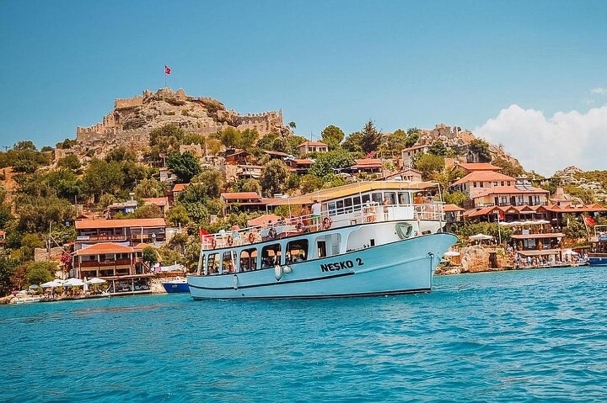 a white boat in the water near a mountain