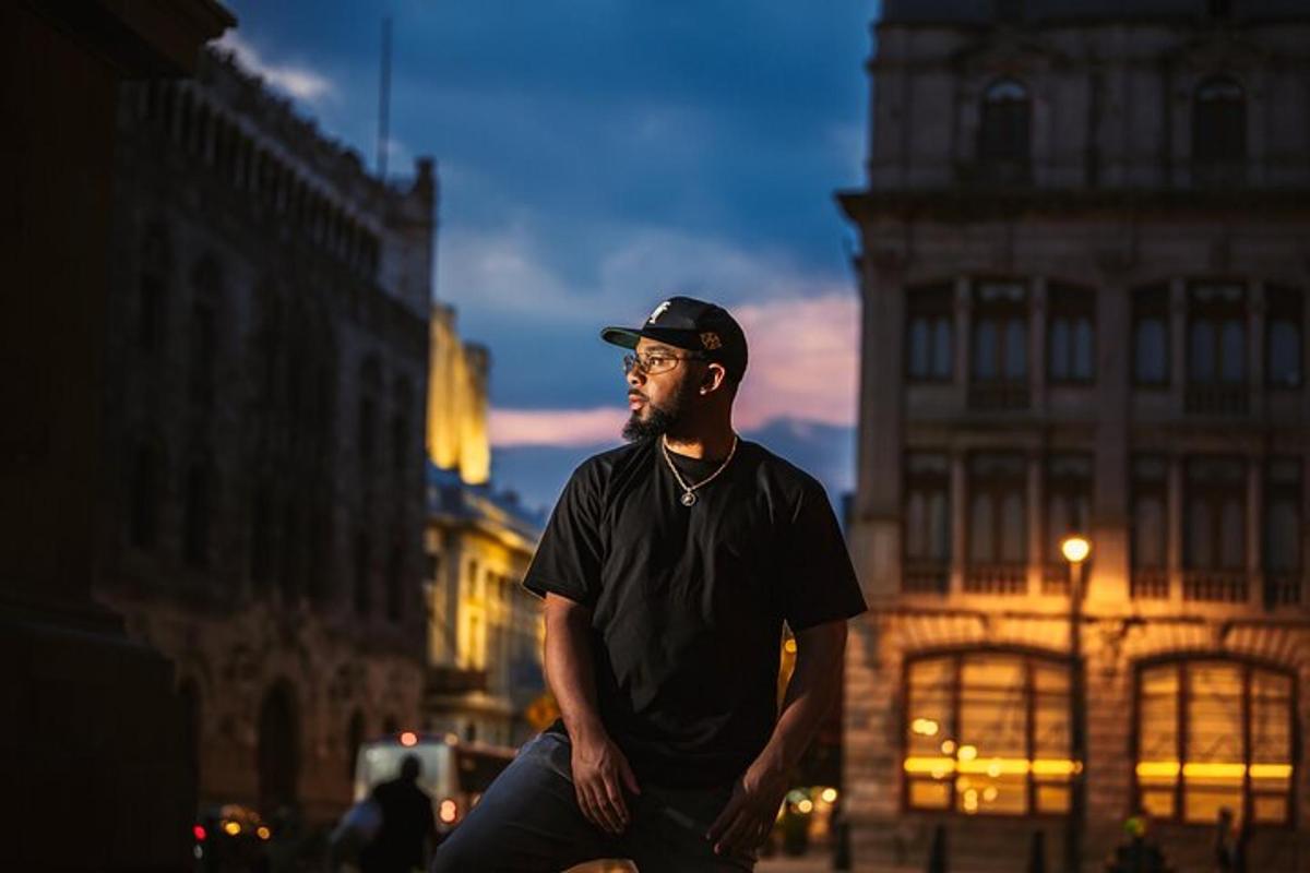 a man wearing a hat standing in a city
