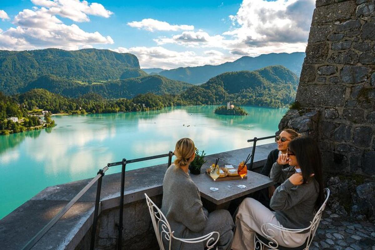three women sitting at a table with a view of a lake
