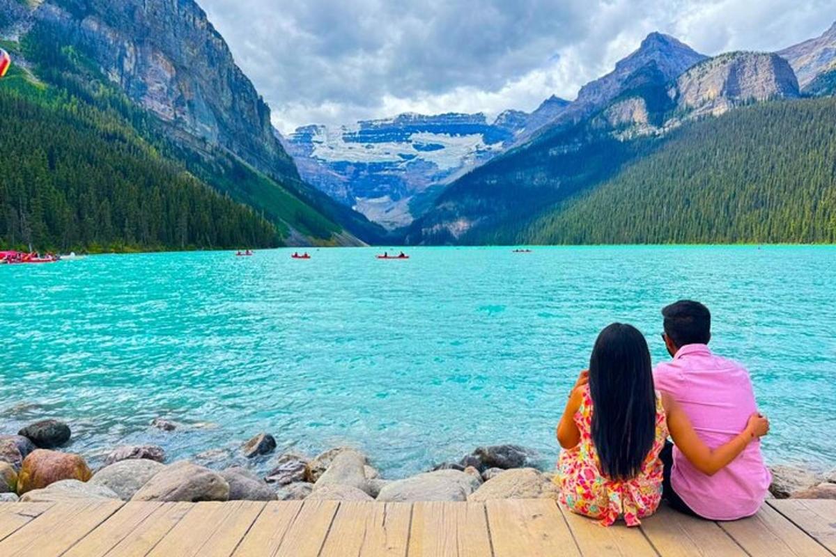 a couple sitting on a dock looking at a lake