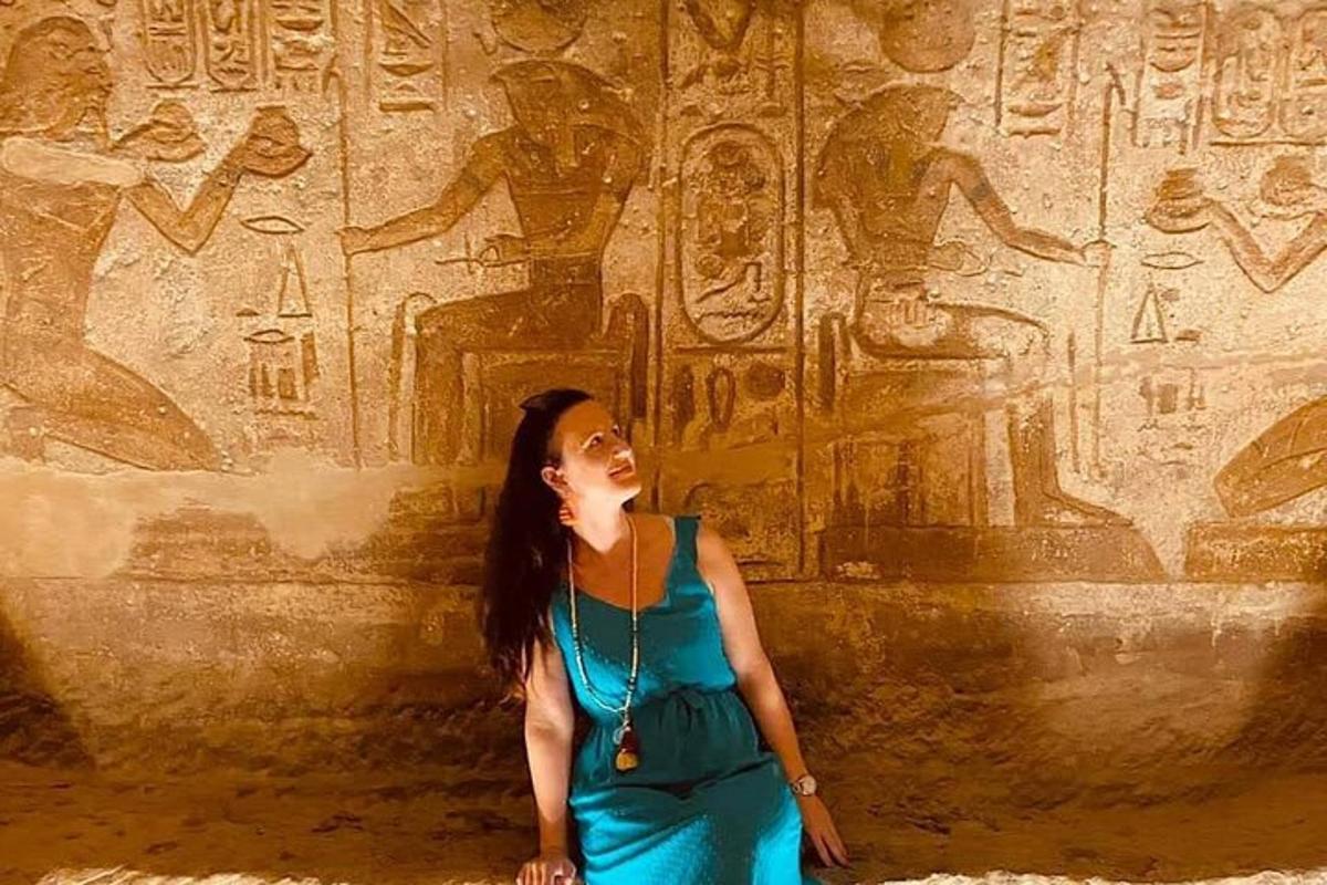 a woman standing in front of a wall with relief