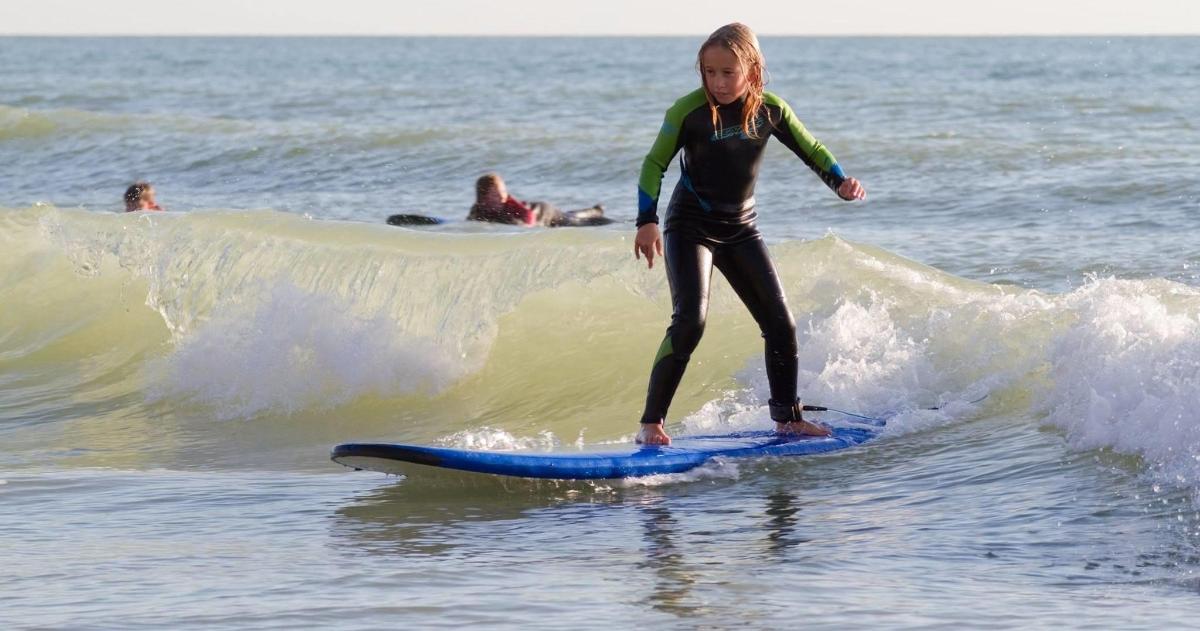 a young girl riding a wave on a surfboard in the ocean