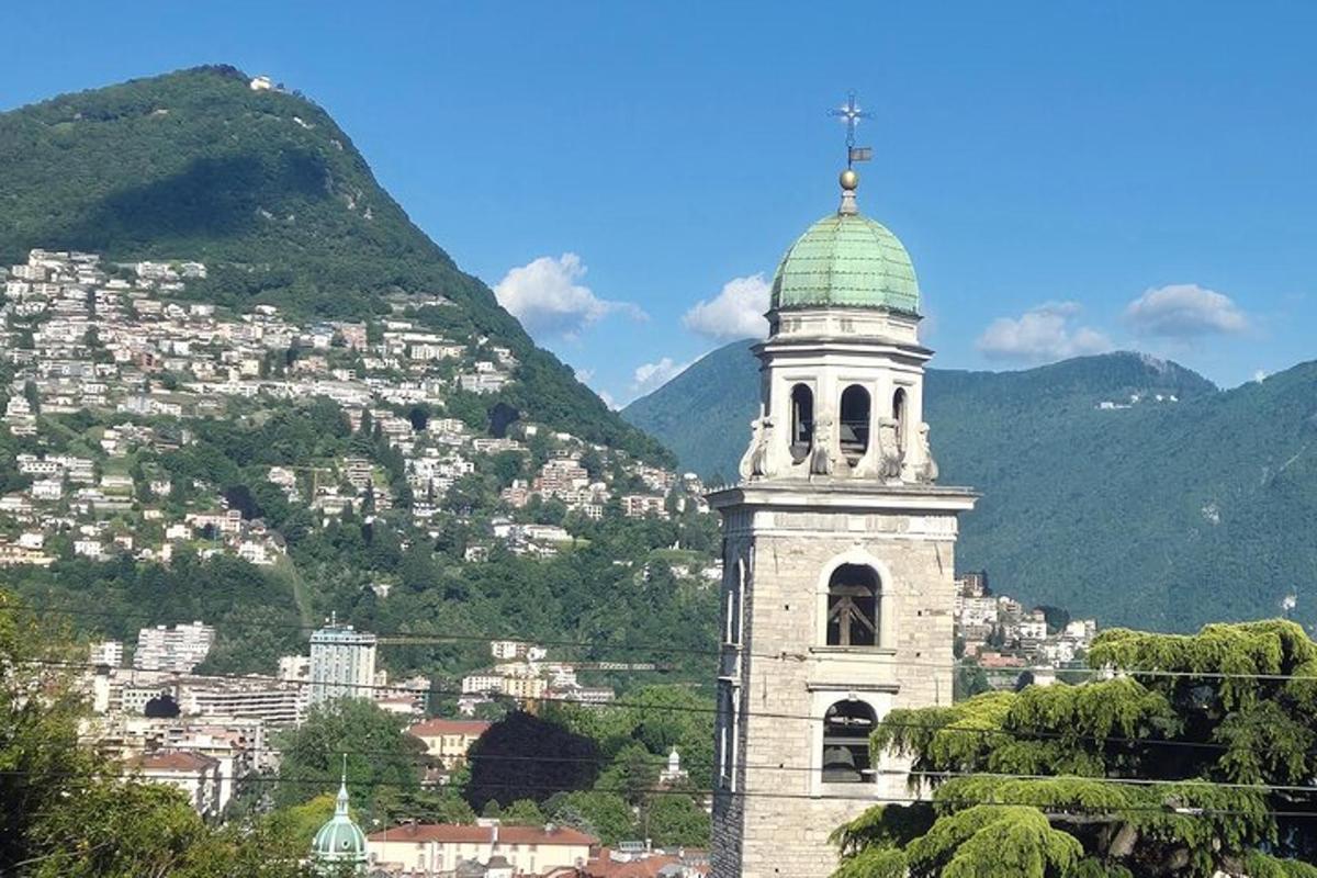 a clock tower with a green roof in front of a city