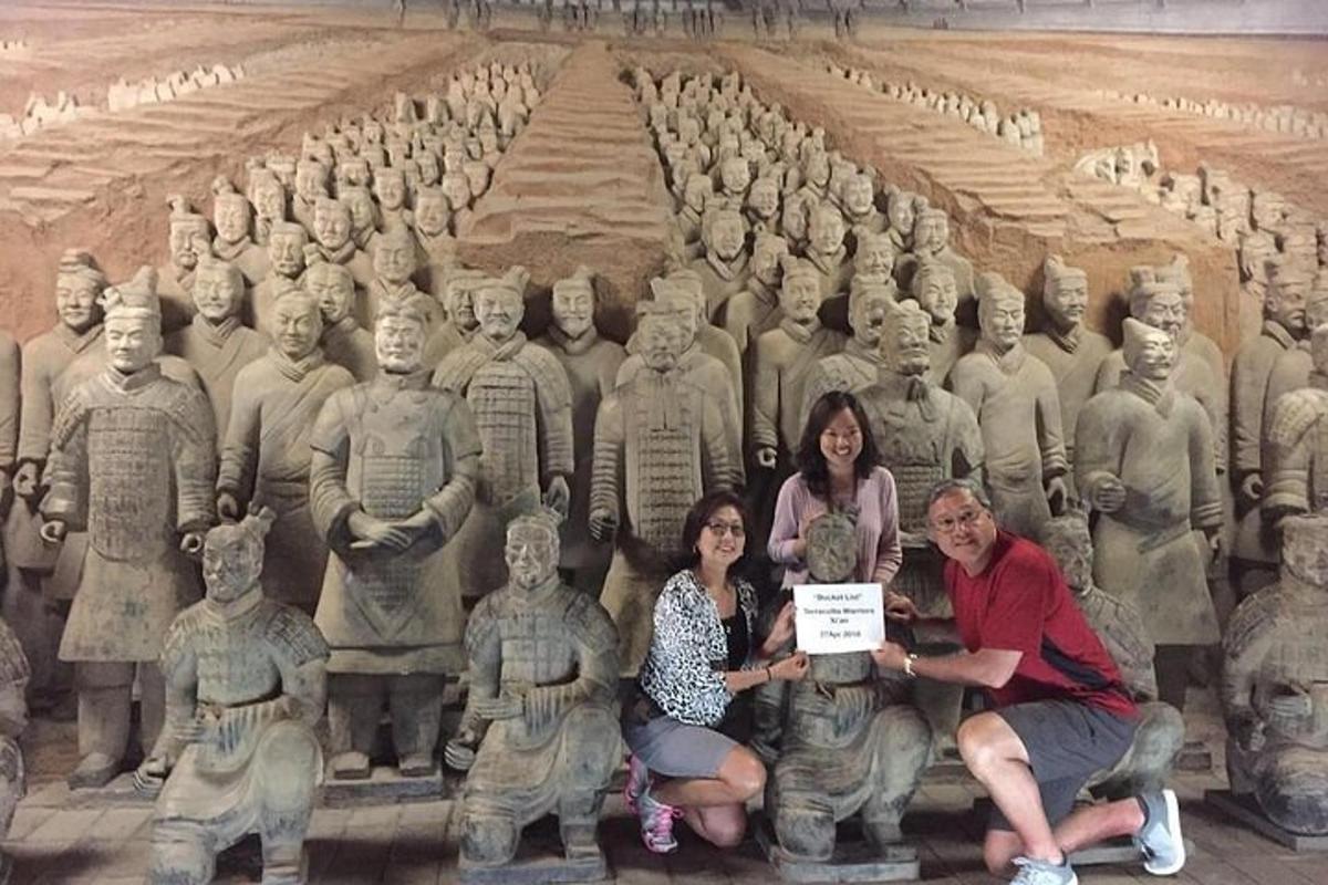 a group of people posing in front of a large statue