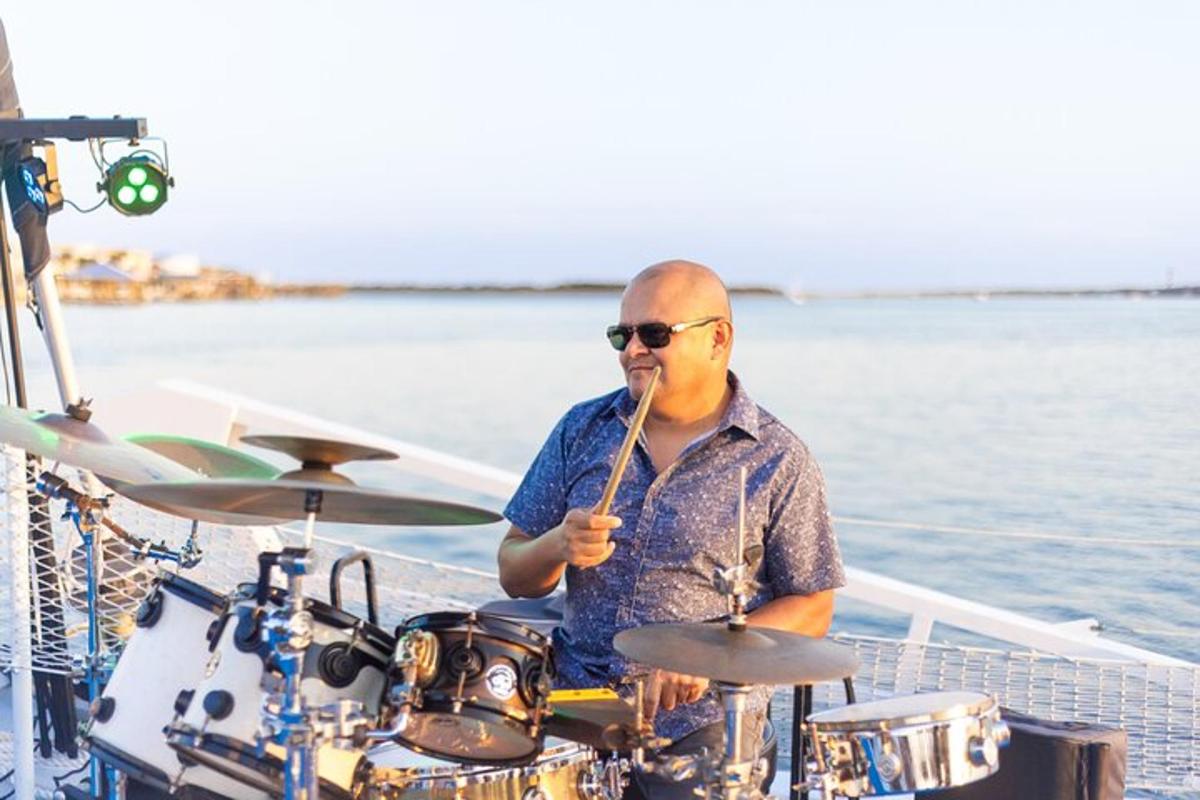 a man playing drums on a boat