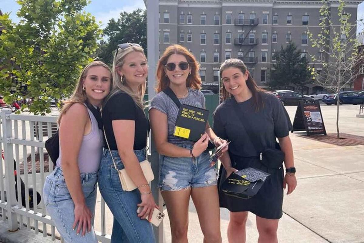 a group of women standing next to a fence