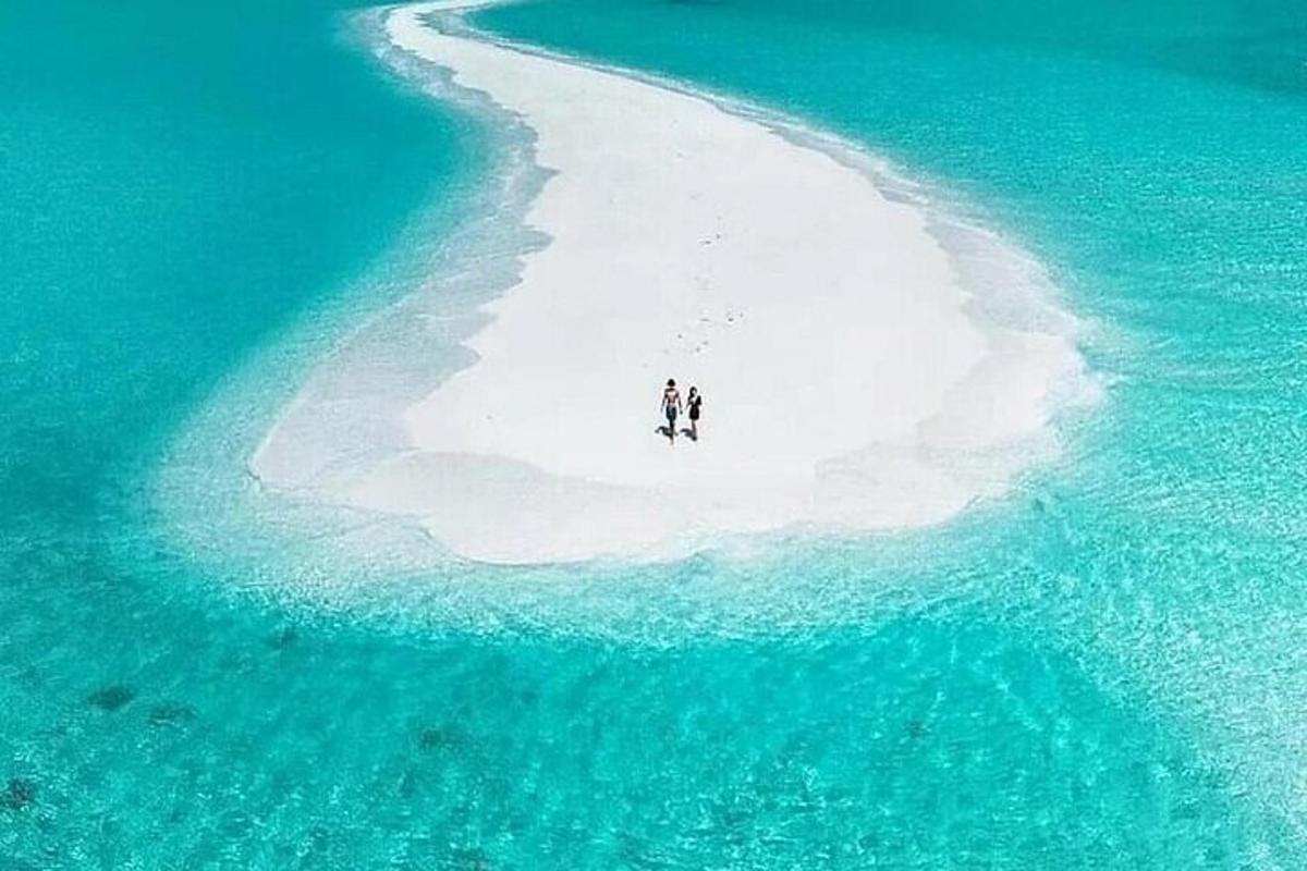 two people standing on an island in the ocean