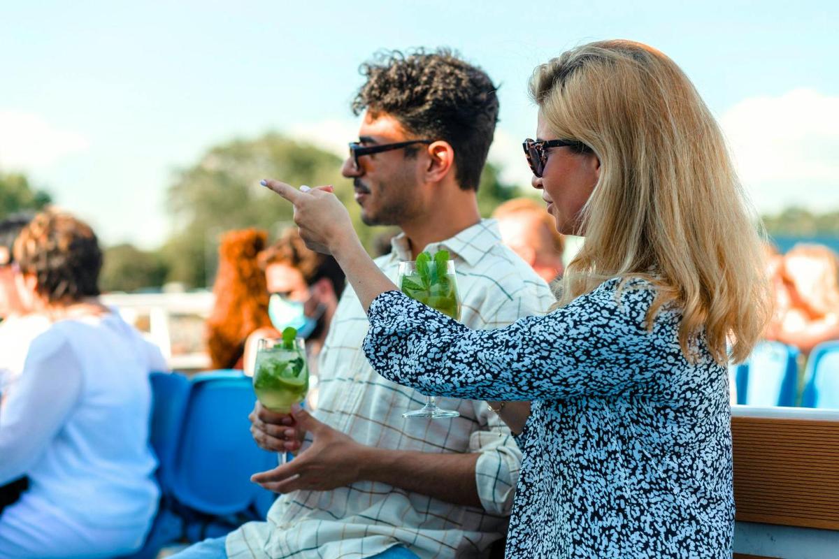 a woman pointing at a man holding a drink