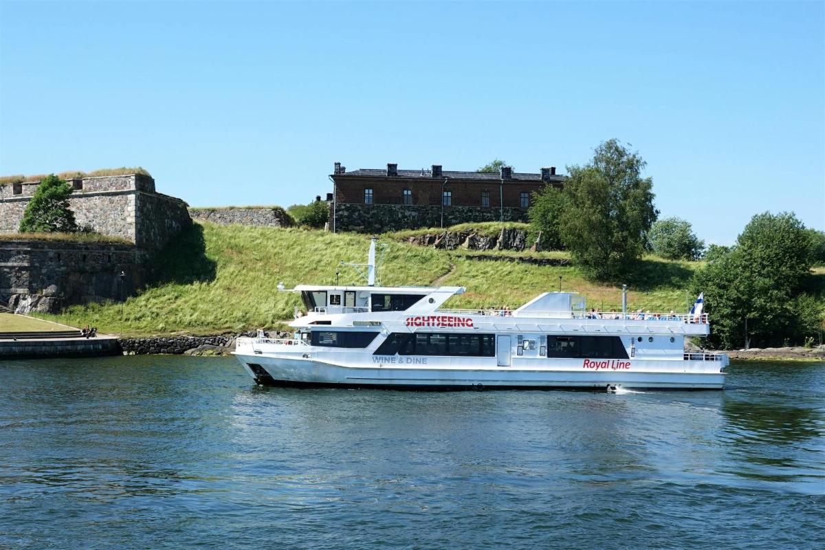 a white boat in the water with a castle in the background