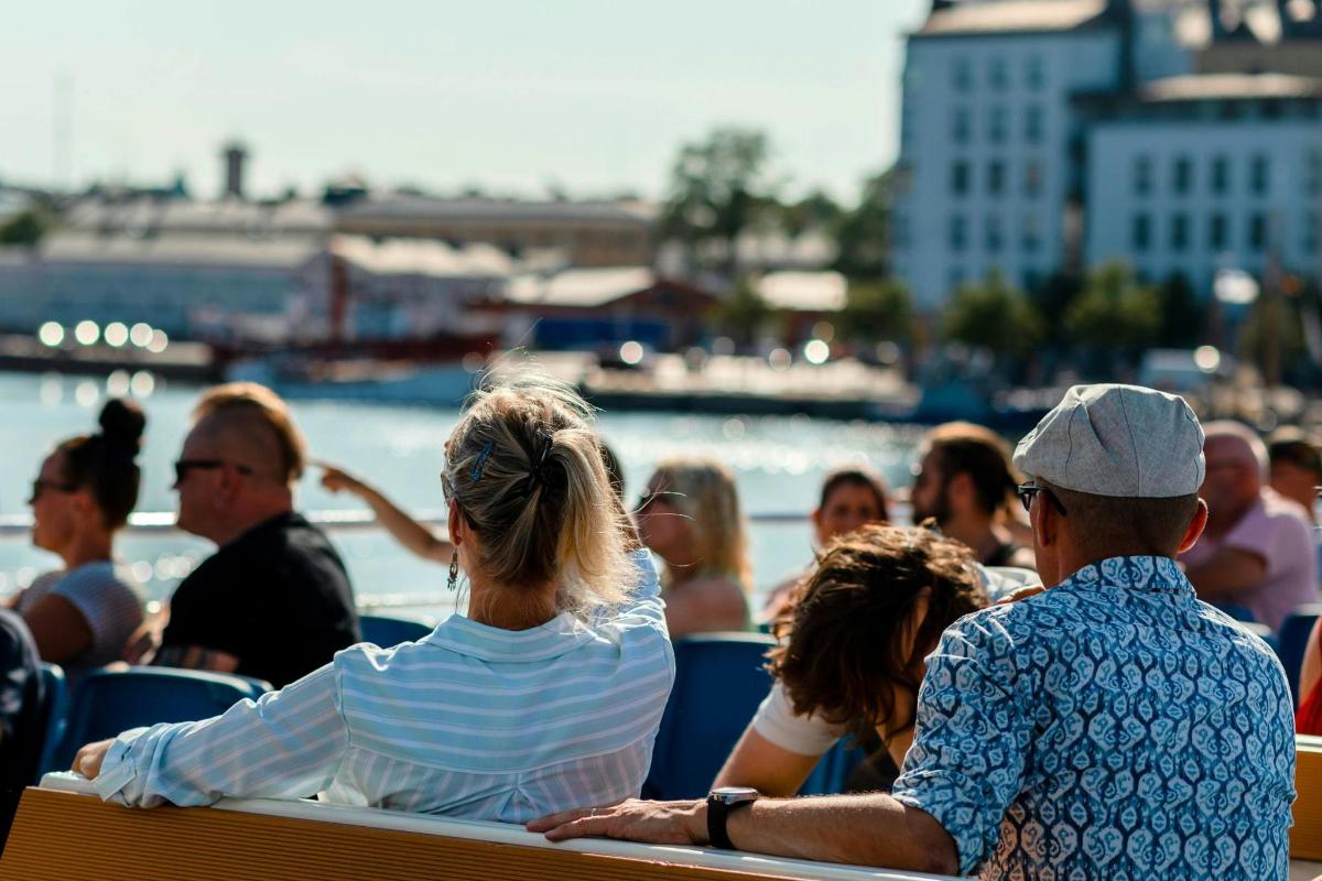 a group of people sitting on a bench by the water