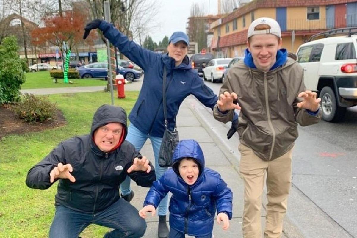 a group of people walking down a sidewalk with their arms out
