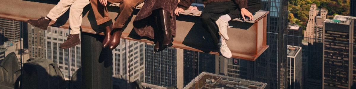 two people standing on a suitcase in a city