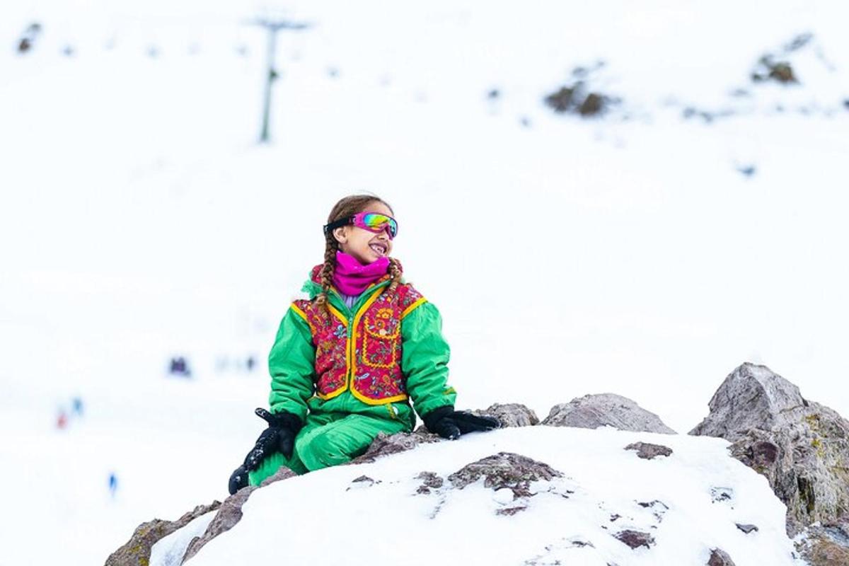 a girl sitting on a rock in the snow