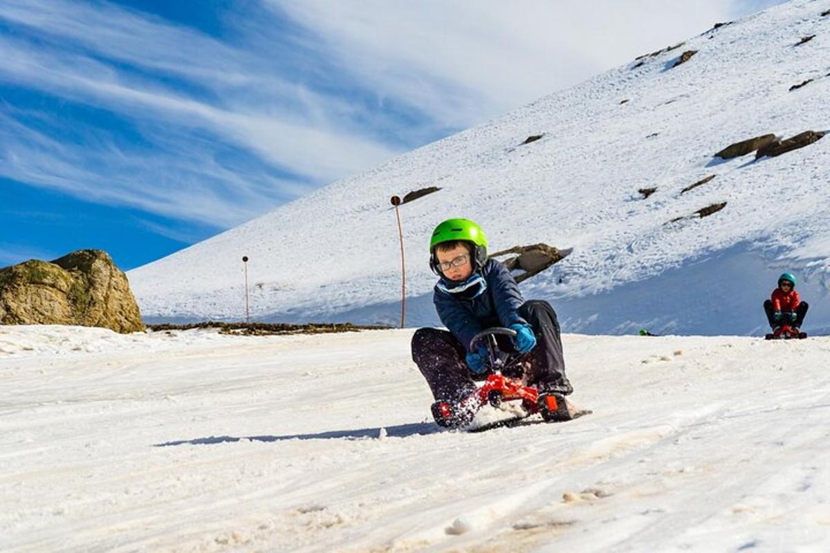 a young child riding a snowboard down a snow covered slope