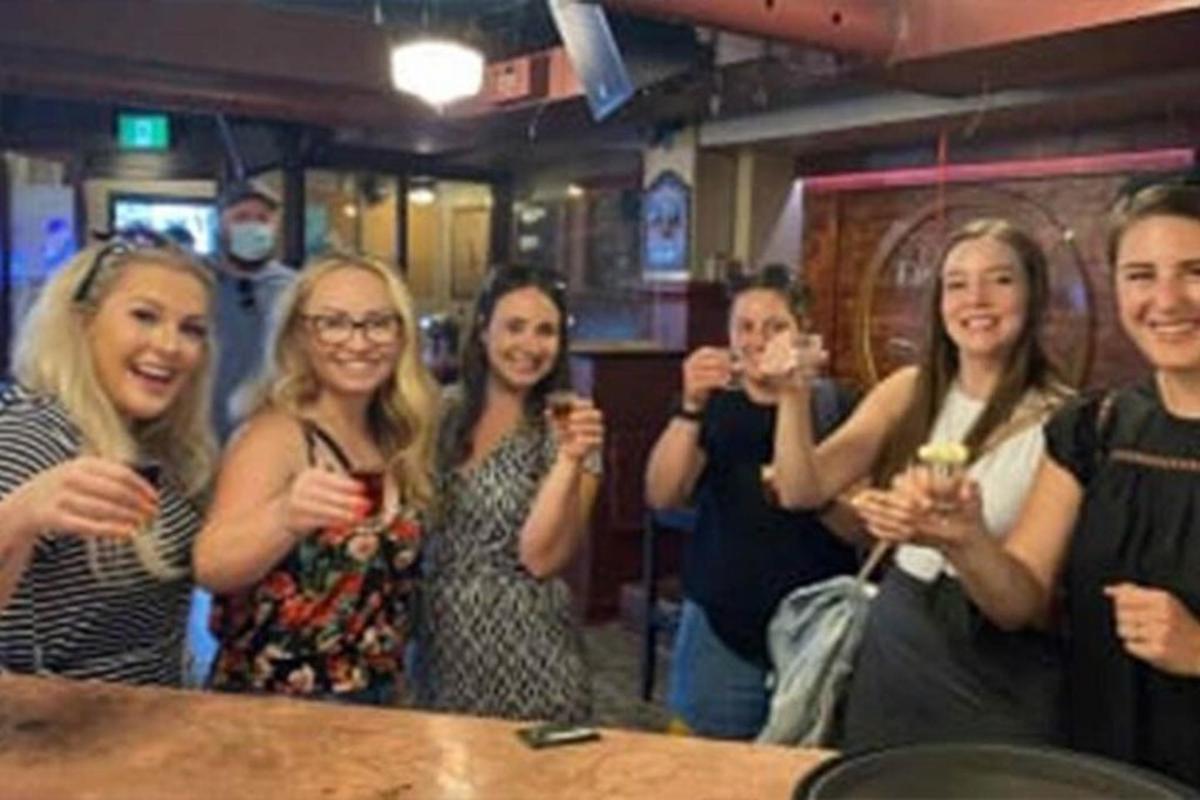 a group of women holding up wine glasses