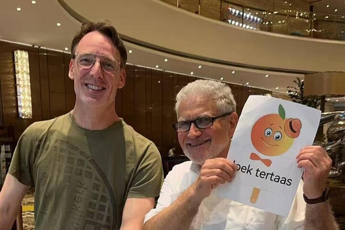two men are holding up a picture of a monkey
