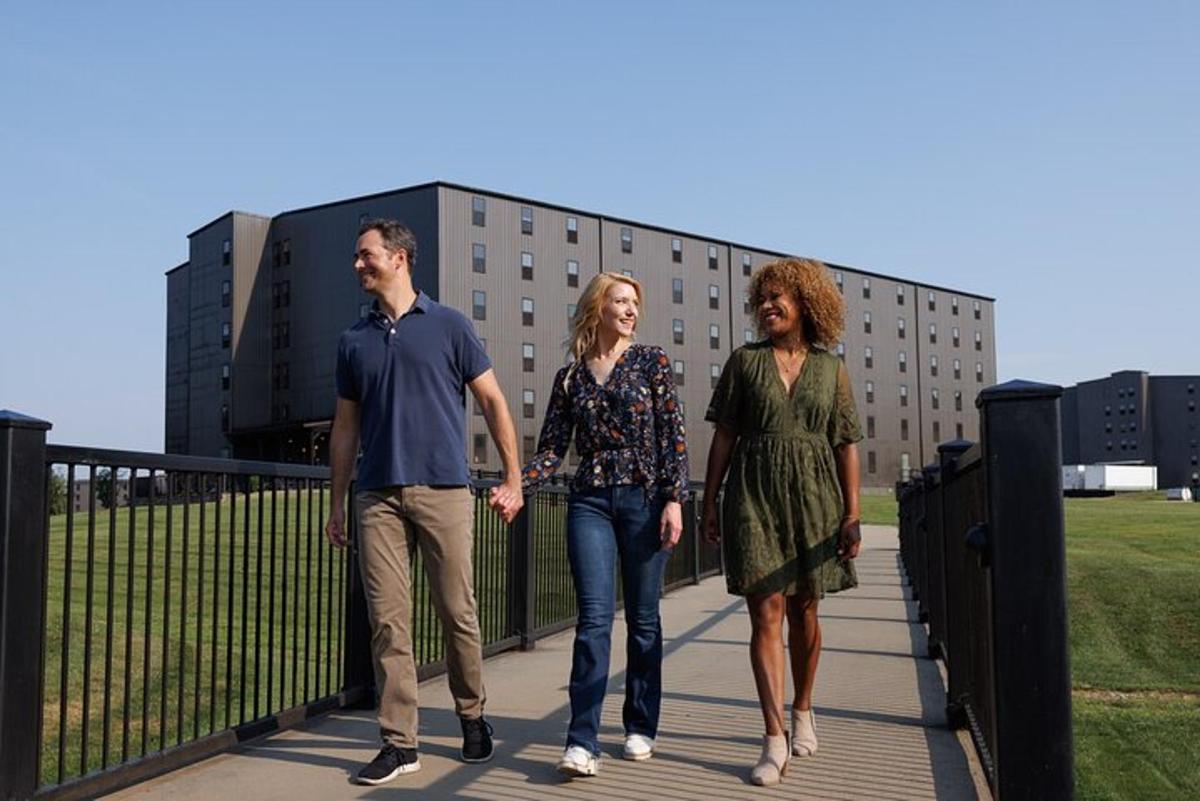 a group of three people walking on a bridge