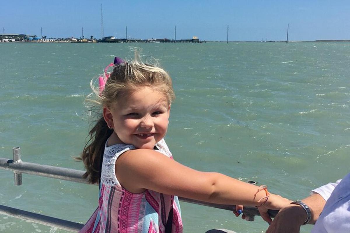 a little girl standing on a boat in the water