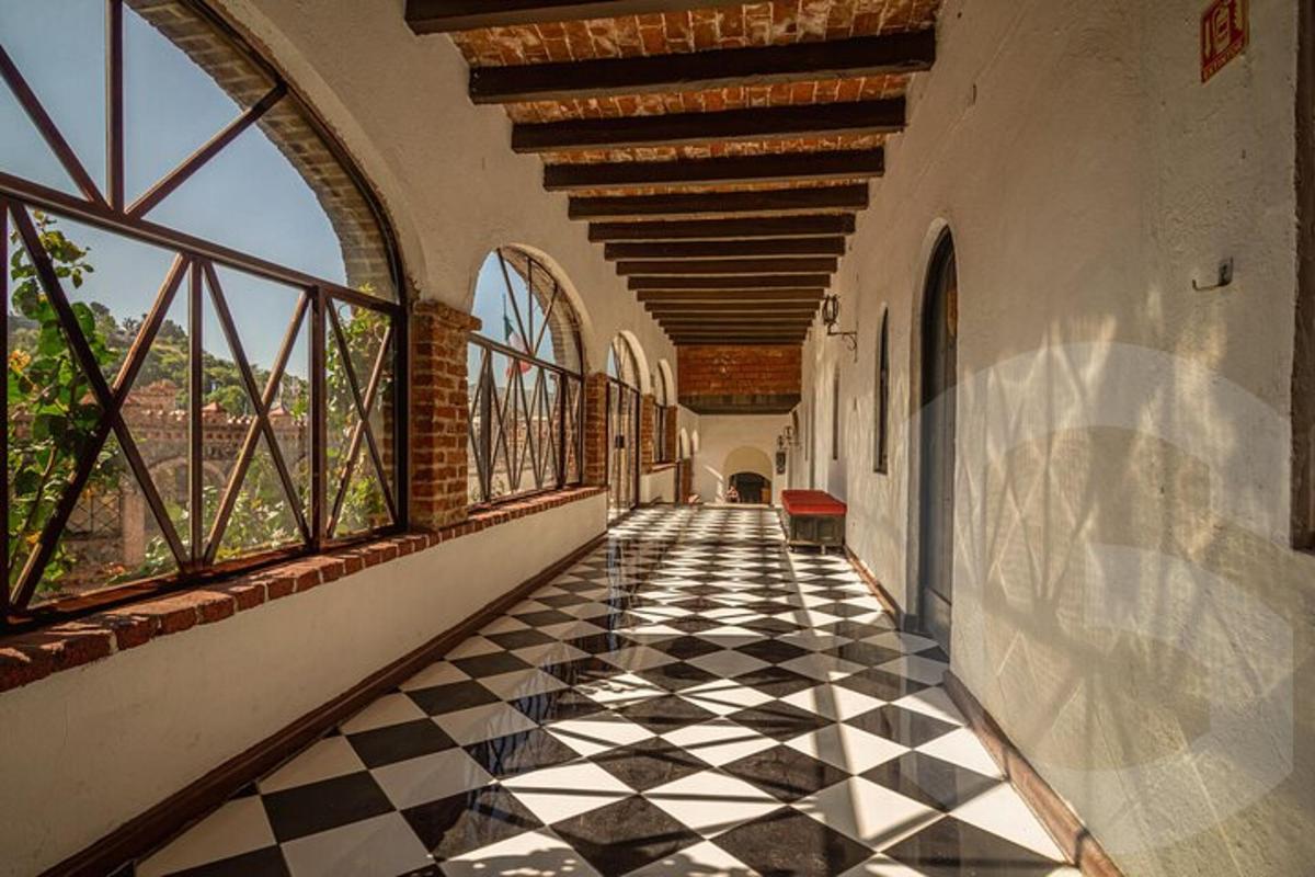 an empty hallway with a checkered floor and windows