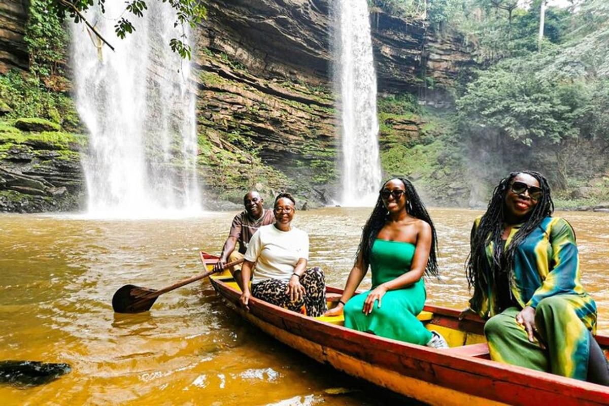 a group of people on a boat in front of a waterfall