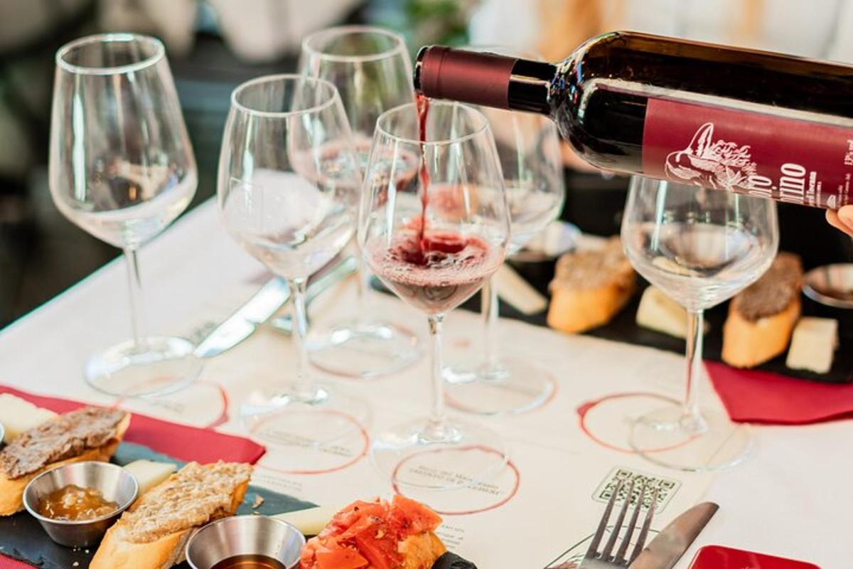 a person pouring wine into wine glasses on a table
