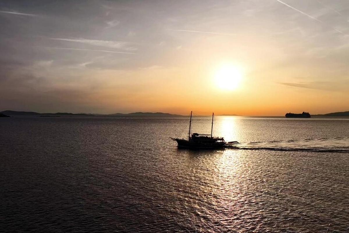 a boat in the water with the sunset in the background