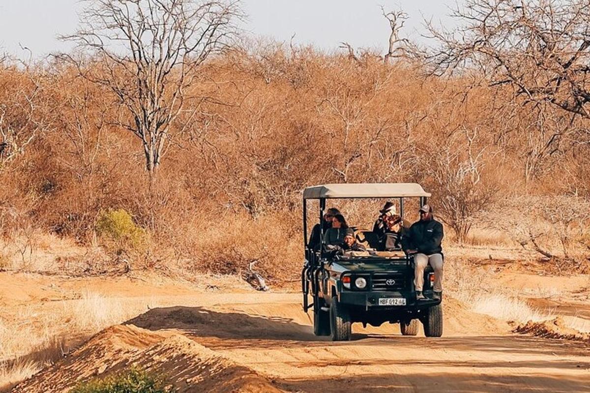 a group of people in a jeep on a dirt road