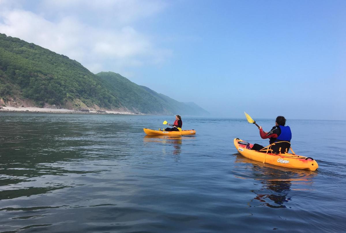 three people in kayaks on a body of water