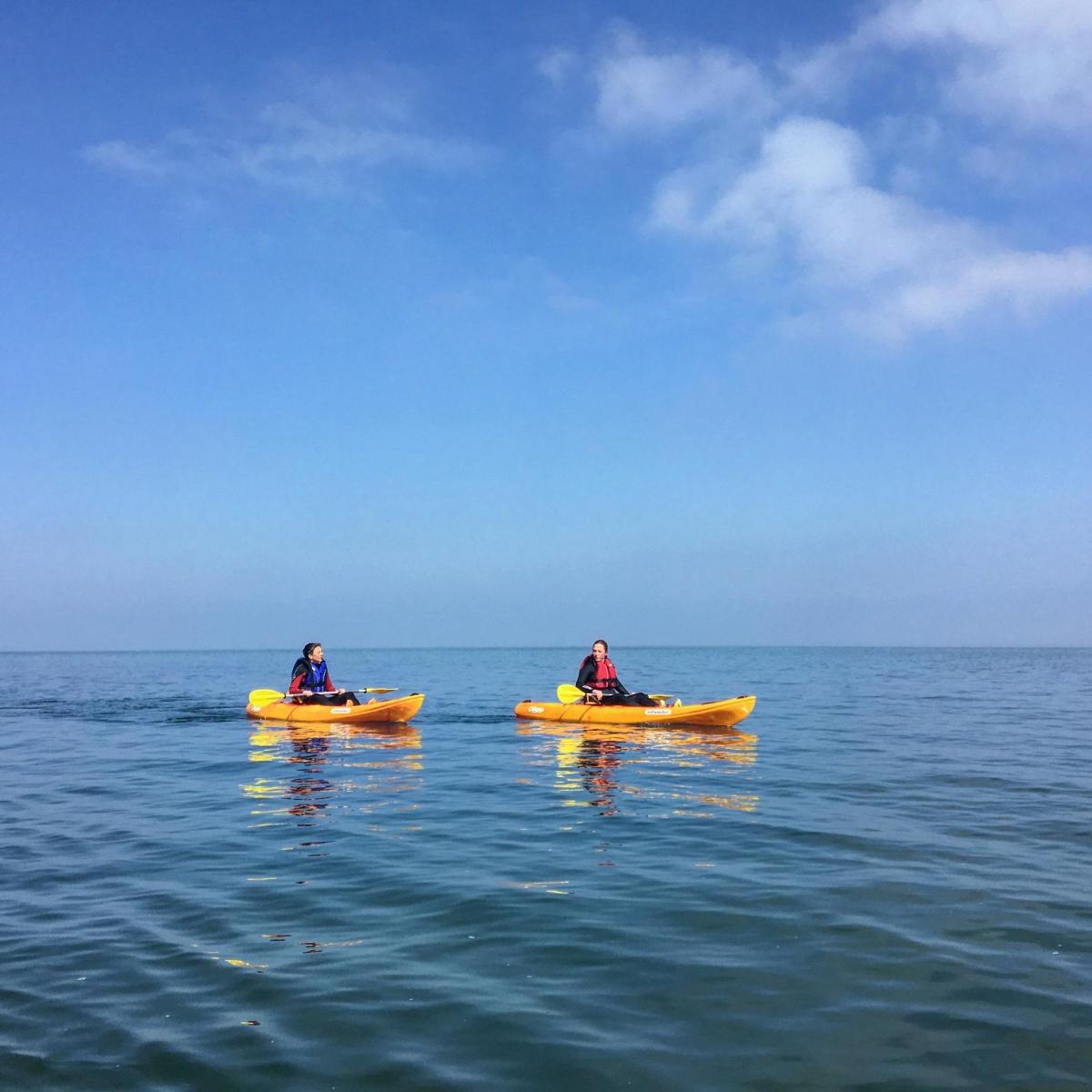 two people in yellow kayaks in the water