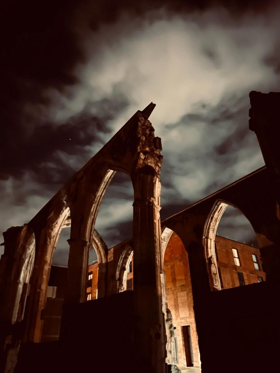 an abandoned building with a cloudy sky in the background