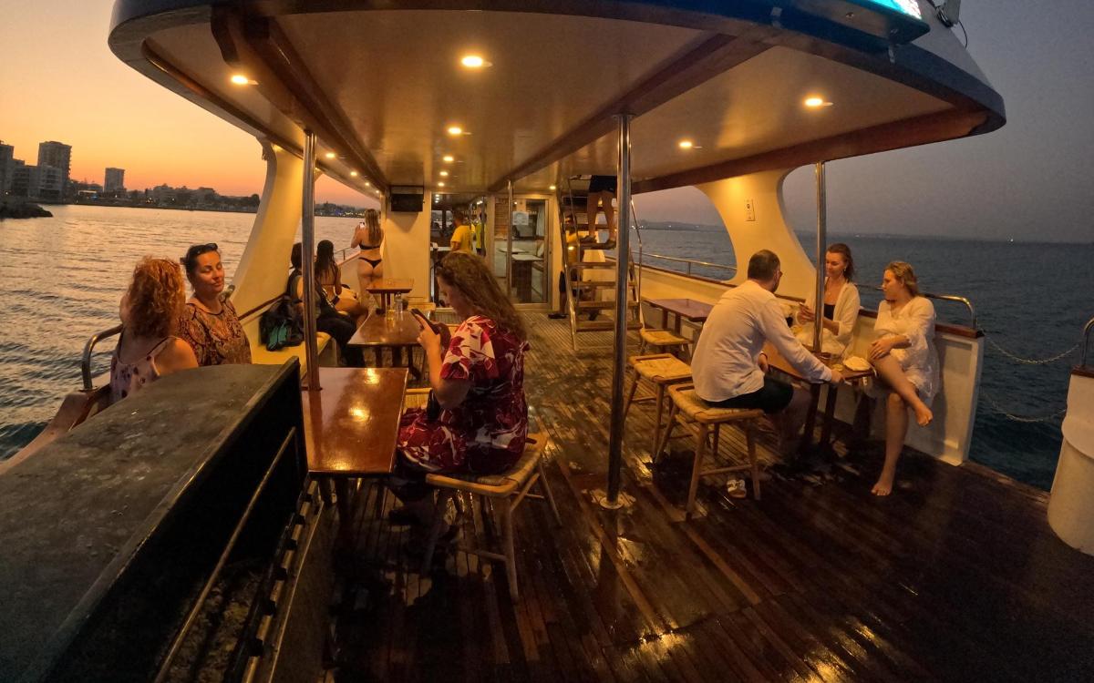 a group of people sitting on the deck of a boat