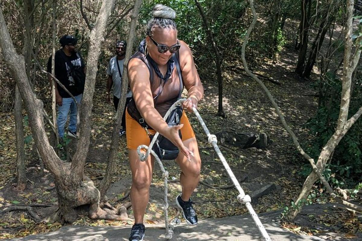 a man walking across a rope in the woods