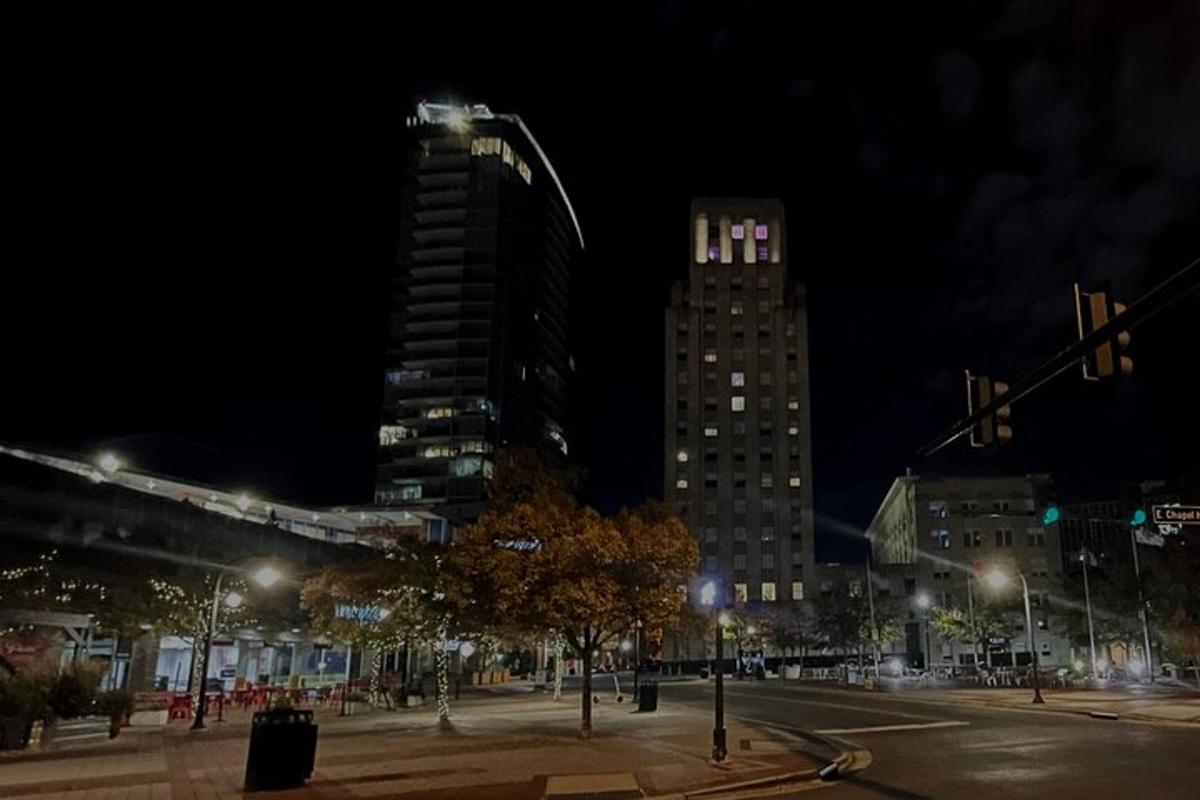 a city street at night with tall buildings