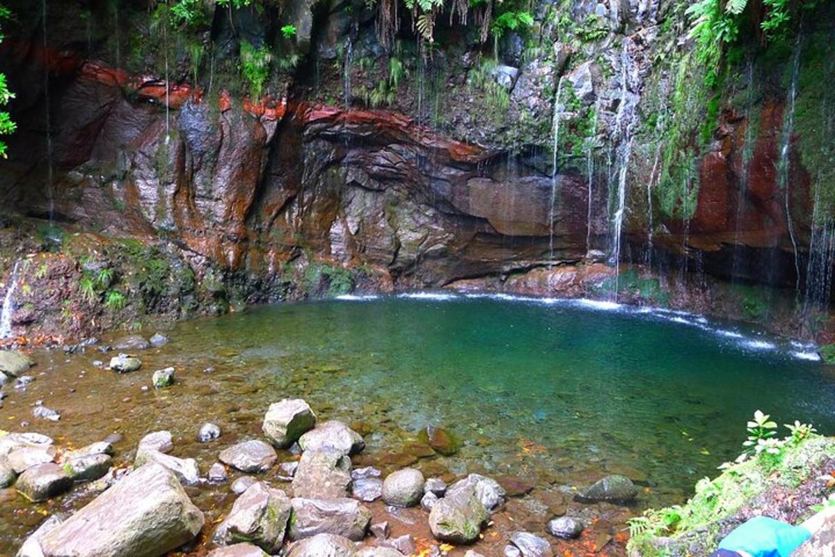 a pool of water in a cave with waterfalls