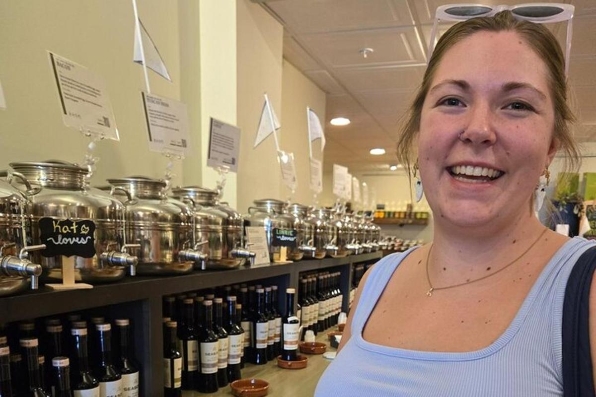 a woman standing in front of a shelf of wine bottles