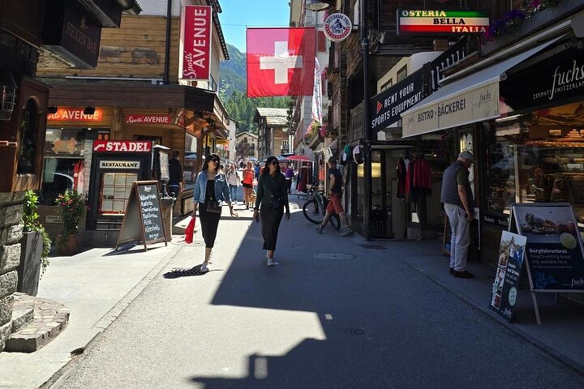 a group of people walking down a street with shops