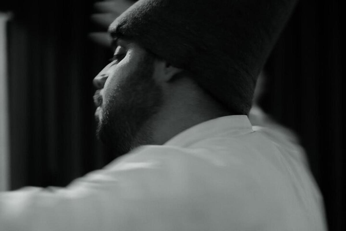 a man wearing a hat and white shirt