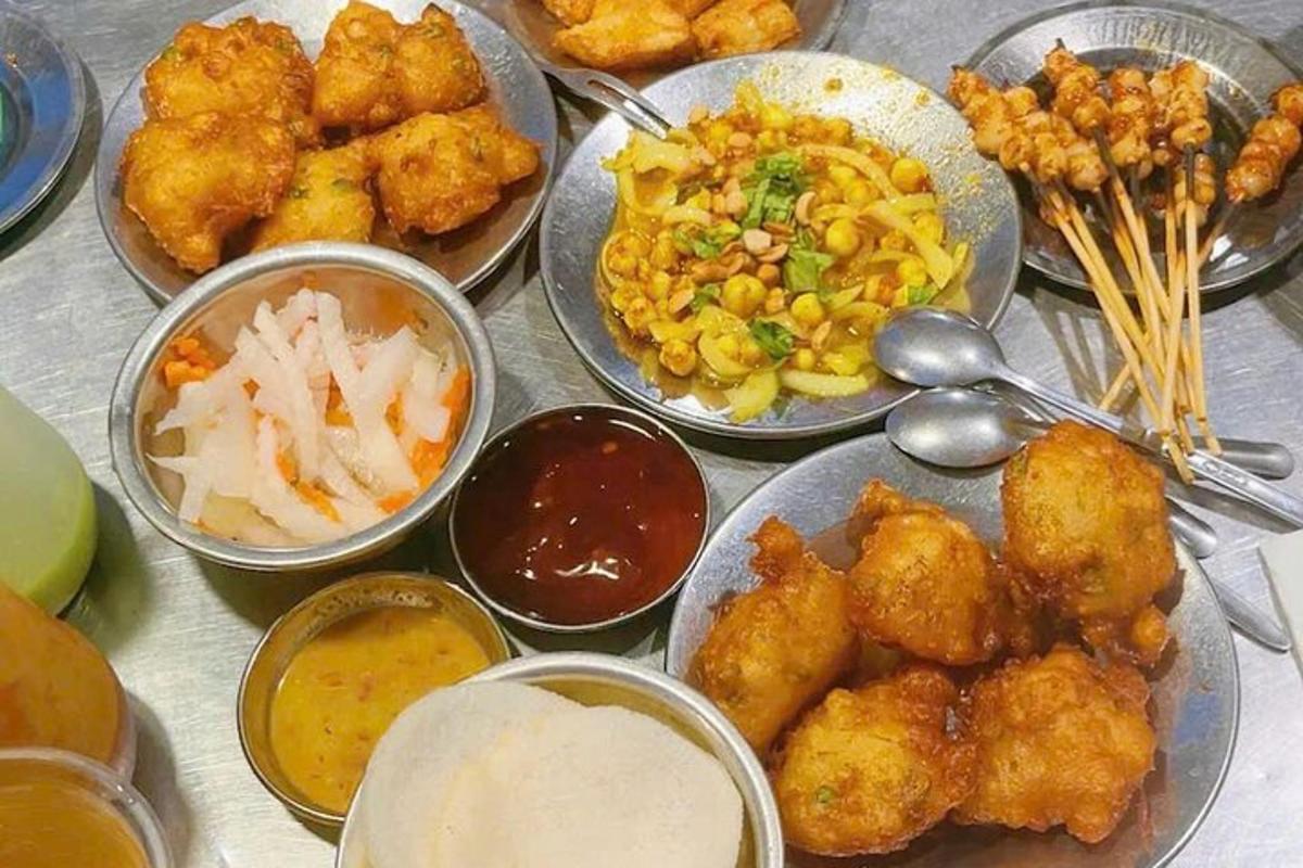một cái bàn được phủ đầy những đĩa thức ăn với nhiều loại thức ăn khác nhau