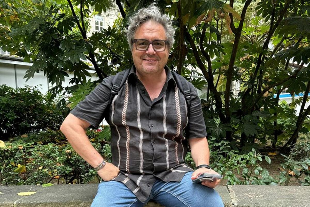 a man sitting on a bench with a cell phone