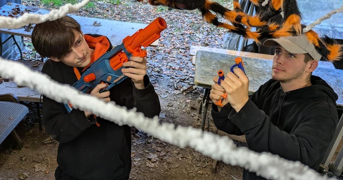 two men holding up a pair of chainsaws